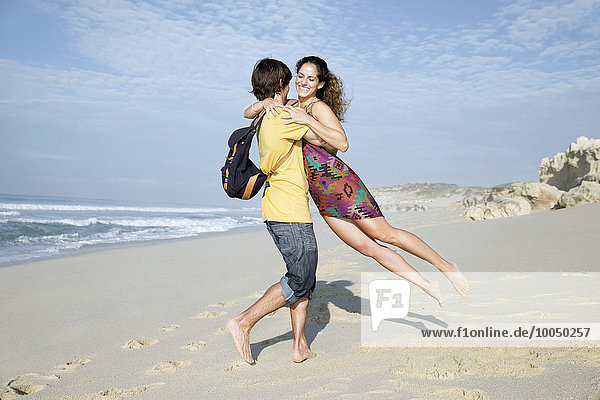 Südafrika  Mann hebt Freundin am Strand hoch