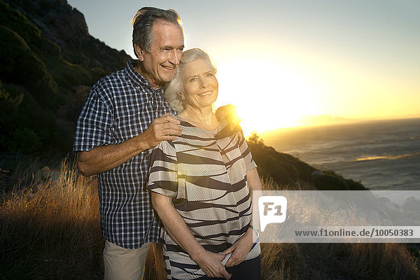 Südafrika  Porträt eines glücklichen Seniorenpaares bei Sonnenuntergang