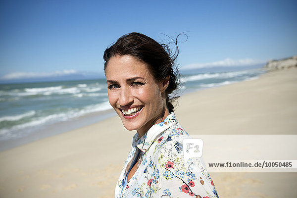 Südafrika  Porträt einer lächelnden Frau am Strand