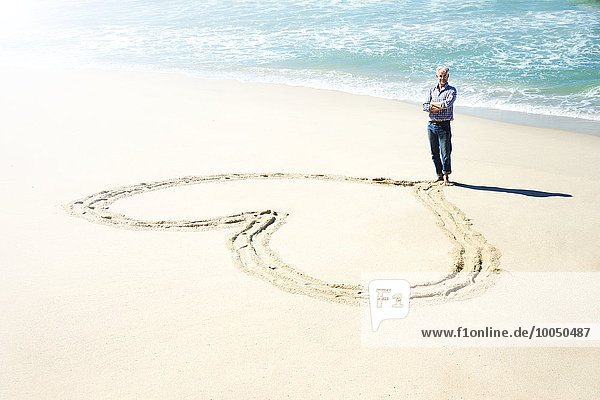 Südafrika  Mann vor dem Herzen in den Sand des Strandes geschnitzt