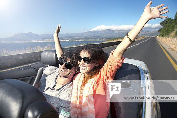 South Africa  happy couple in convertible on coastal road