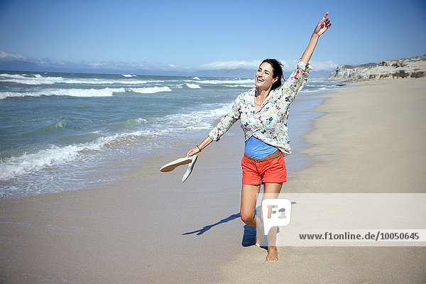 Südafrika  fröhliche Frau tanzt am Strand