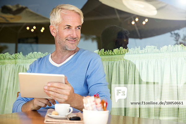 Porträt eines lächelnden Mannes mit digitalem Tablett