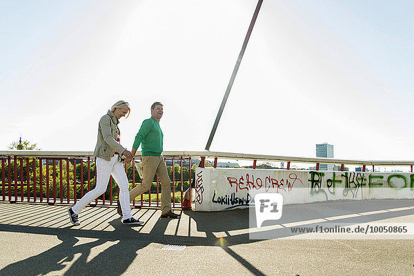 Deutschland  Mannheim  Ehepaar überquert Brücke  Händchen haltend