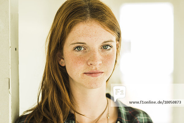 Portrait of redheaded young woman with freckles