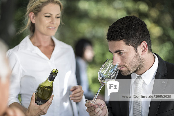 Client in restaurant examining white wine