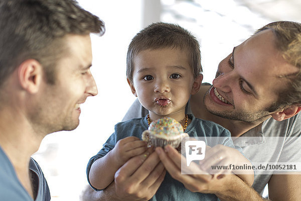 Gay couple baking cake with son