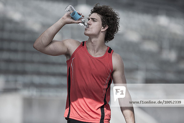 Young sportsman drinking water