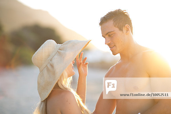 Junges Paar am Strand im Gespräch