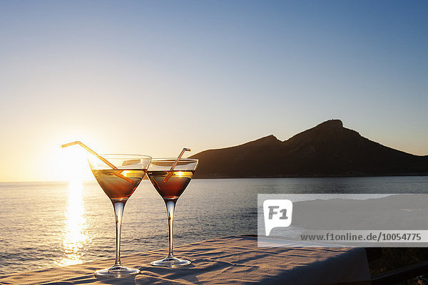 Sonnenuntergang über dem Meer mit zwei Cocktails auf dem Tisch  Mallorca  Spanien