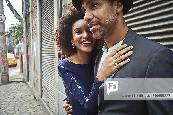 Couple standing together in urban environment  hugging  smiling