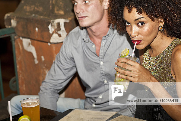 Ein Paar sitzt zusammen in der Bar und trinkt.