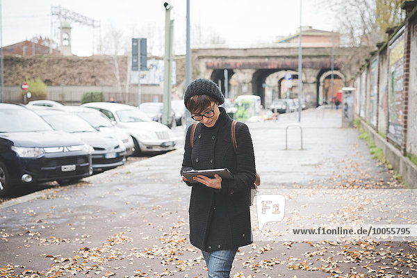 Junge Frau mit digitalen Tablette auf der Straße
