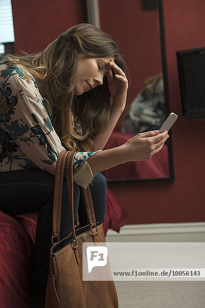 Worried looking woman using phone