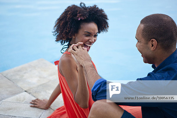 Stylish couple laughing and holding hands at hotel poolside  Rio De Janeiro  Brazil