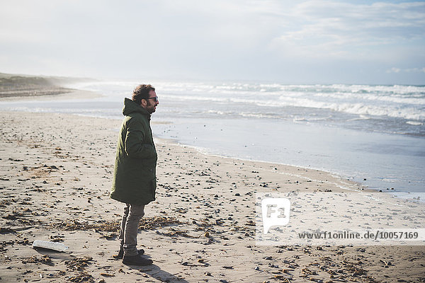Mittlerer Erwachsener Mann mit Blick aufs Meer am windigen Strand  Sorso  Sassari  Sardinien  Italien