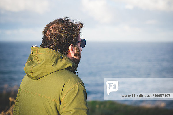 Mittlerer erwachsener Mann mit Blick auf das Meer von der windigen Küste  Sorso  Sassari  Sardinien  Italien
