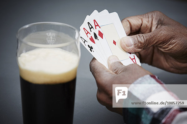 Mann mit vier Ass-Karten mit Bier