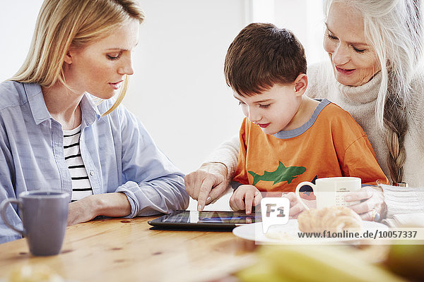 Drei Generationen Familie mit digitalem Tablett