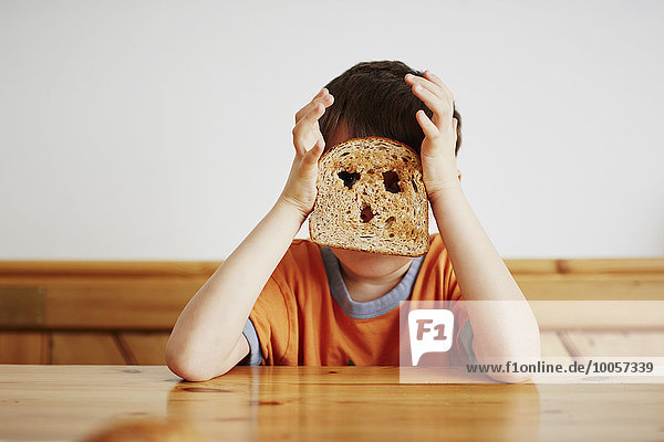 Junge bedeckt Gesicht mit Toast