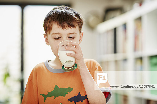 Kleiner Junge trinkt ein Glas Milch.