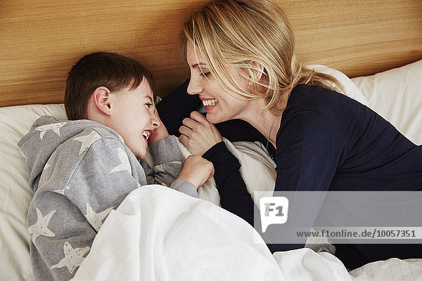 Mother and son laughing in bed