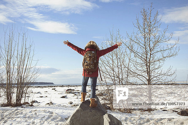 Woman standing on rock with arms out  Anchorage  Alaska