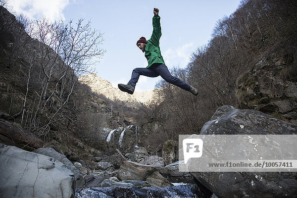 Mann springt über den Fluss Toce,  Premosello,  Verbania,  Piemont,  Italien