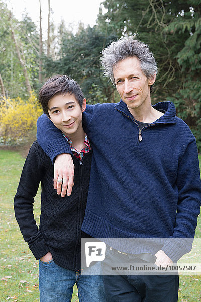 Portrait of mature man and teenage son in garden