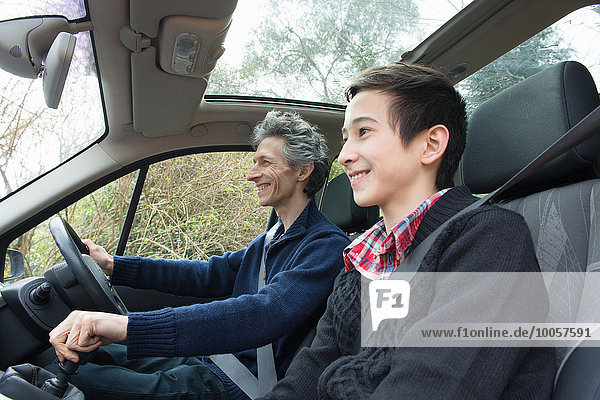 Mature man and teenage son driving car