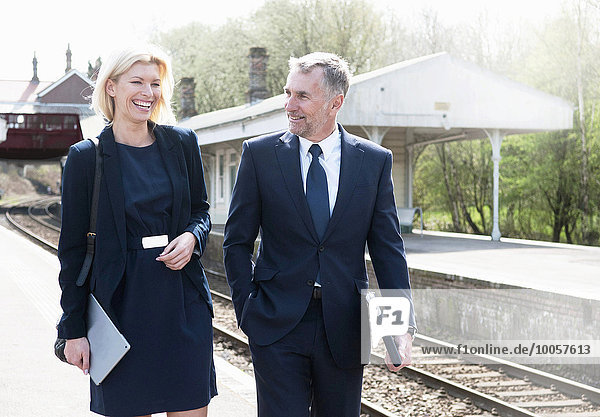 Businessman and woman talking on railway platform