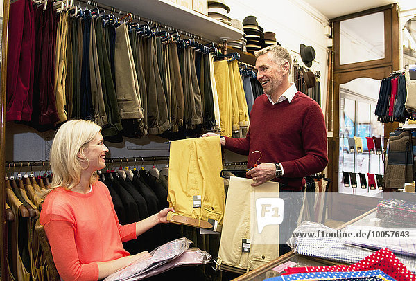 Couple browsing trousers in tailors shop