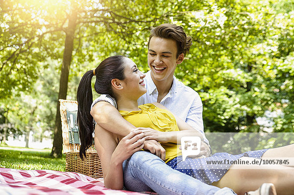 Junges Paar kuschelt auf Picknickdecke