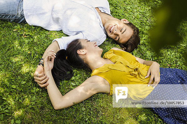Hochwinkelansicht des jungen Paares auf Gras liegend