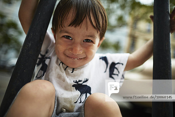 Porträt eines lächelnden Jungen zwischen den Geländern