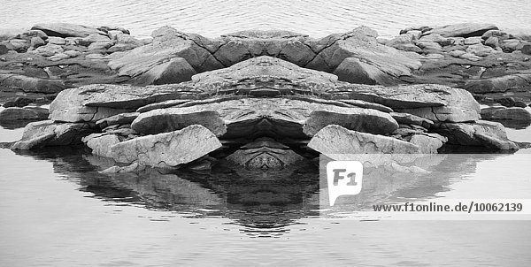Schwarz-weißes symmetrisches Detail von Felsen und Meer