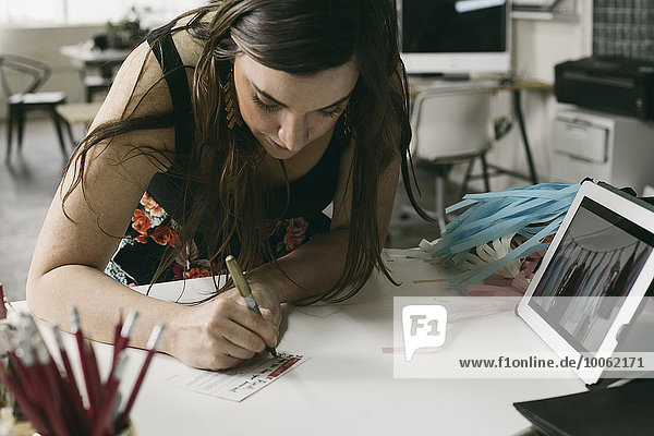 Female designer making note in design studio
