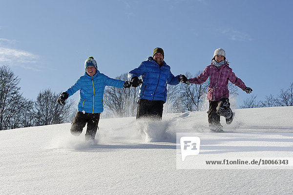 Father and two children running in deep snow  Bad Heilbrunn  Upper Bavaria  Bavaria  Germany  Europe