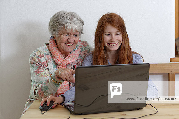 Granddaughter and grandmother using laptop  Bavaria  Germany  Europe
