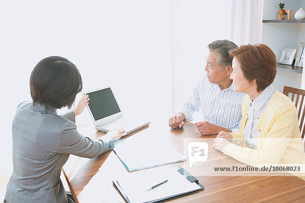 Senior Japanese couple consulting with financial planner