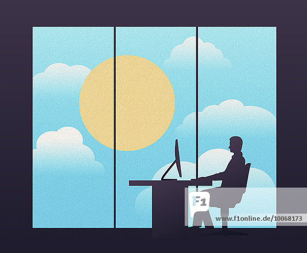 Geschäftsmann arbeitet am Schreibtisch vor Fenster mit großer Sonne