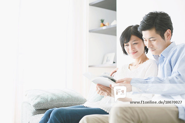 Japanese couple on the sofa with book