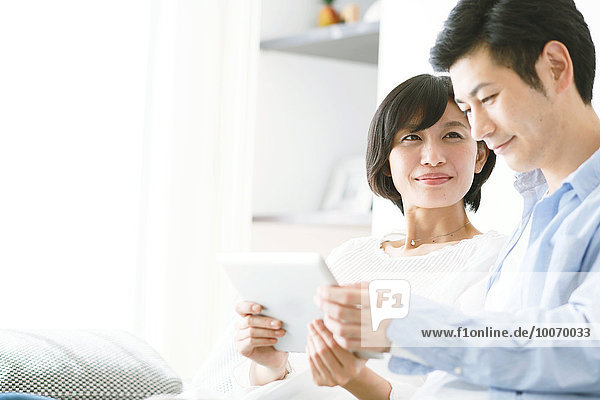 Japanese couple on the sofa with tablet