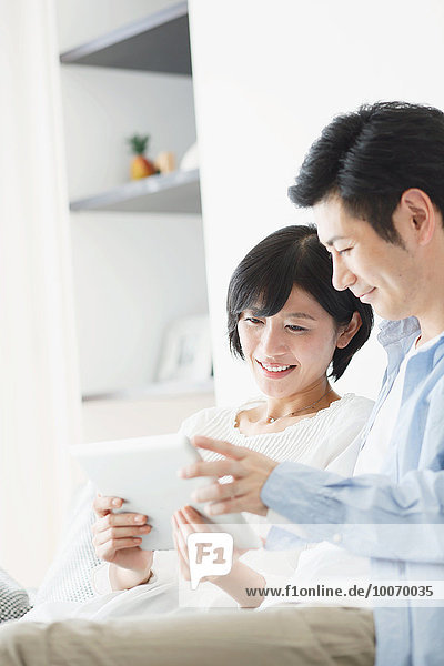 Japanese couple on the sofa with tablet
