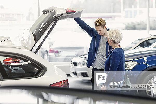 Mutter und Sohn untersuchen das Auto im Autohaus