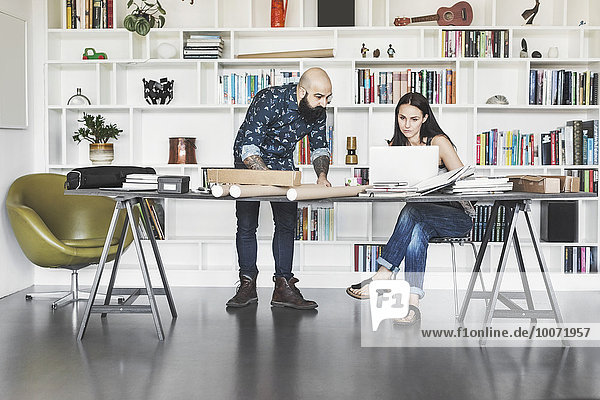 Architects working at table in home office