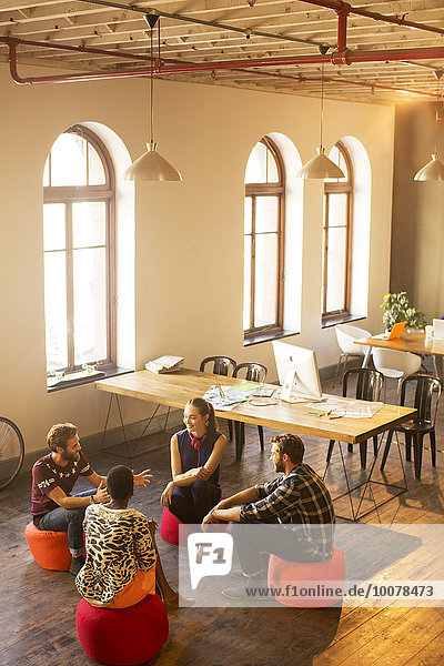Kreative Geschäftsleute reden im Kreis im Büro