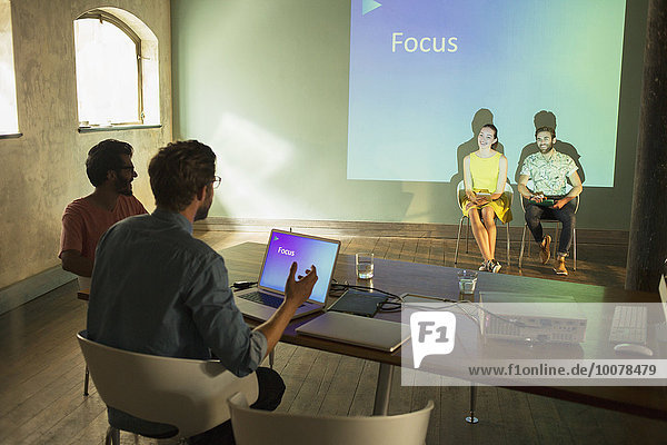Geschäftsleute bei der Vorbereitung einer audiovisuellen Präsentation auf Focus