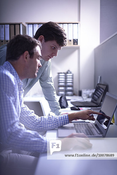 Architects working at laptop in office