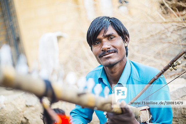 Indian man holding traditional instrument